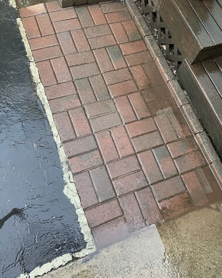 The same brick paver walkway after pressure washing, with clean red brick and crisp mortar lines.